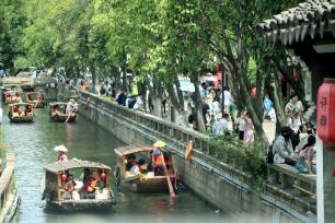 苏州：游客乘手摇小木船在平江路水巷游玩