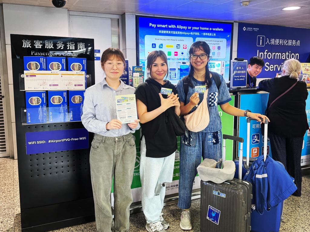 5月24日，泰国游客（中、右）手持“Shanghai Pass”与工作人员合影。（图源：新华社）.jpg