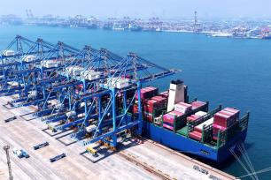 山东青岛：货轮装载着外贸集装箱驶入港口