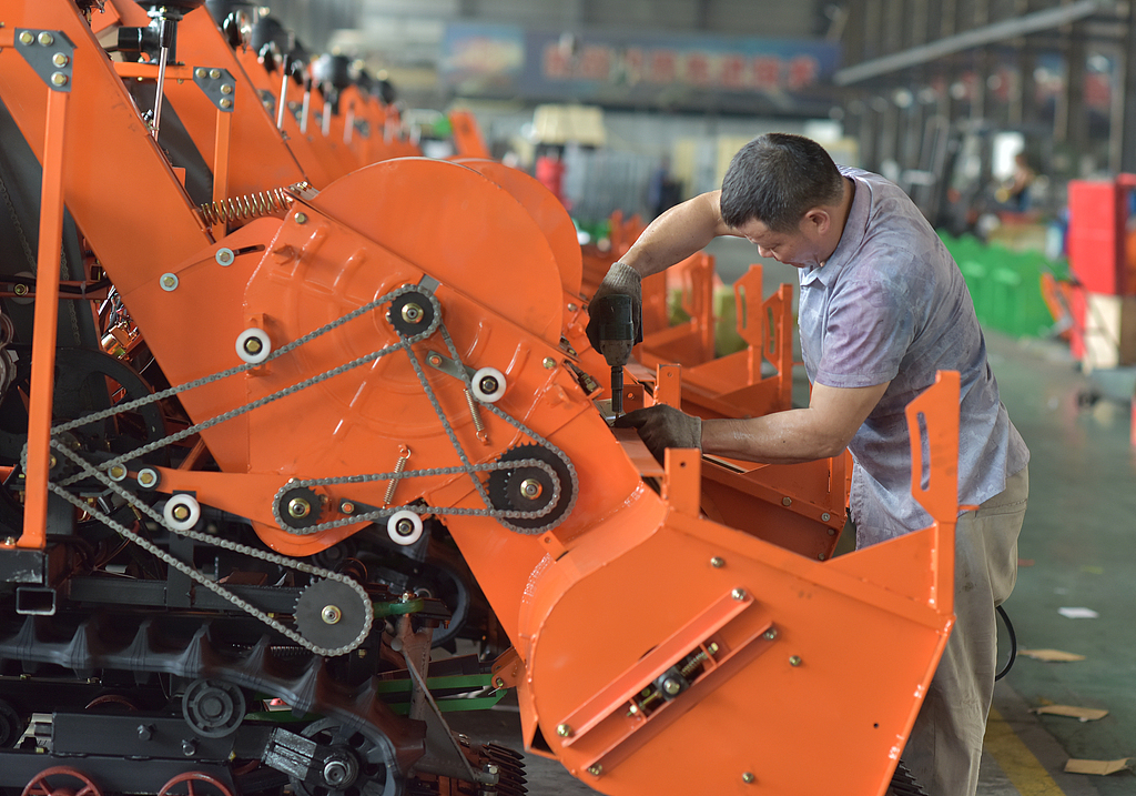 湖南娄底：工人在车间组装收割机