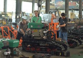 湖南娄底：工人在车间组装收割机