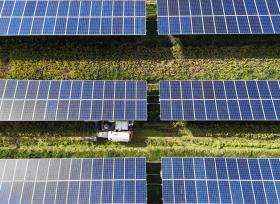 浙江乐清：收割机在光伏板下收稻谷