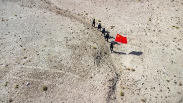 新疆喀什：民警手擎五星红旗巡逻边境