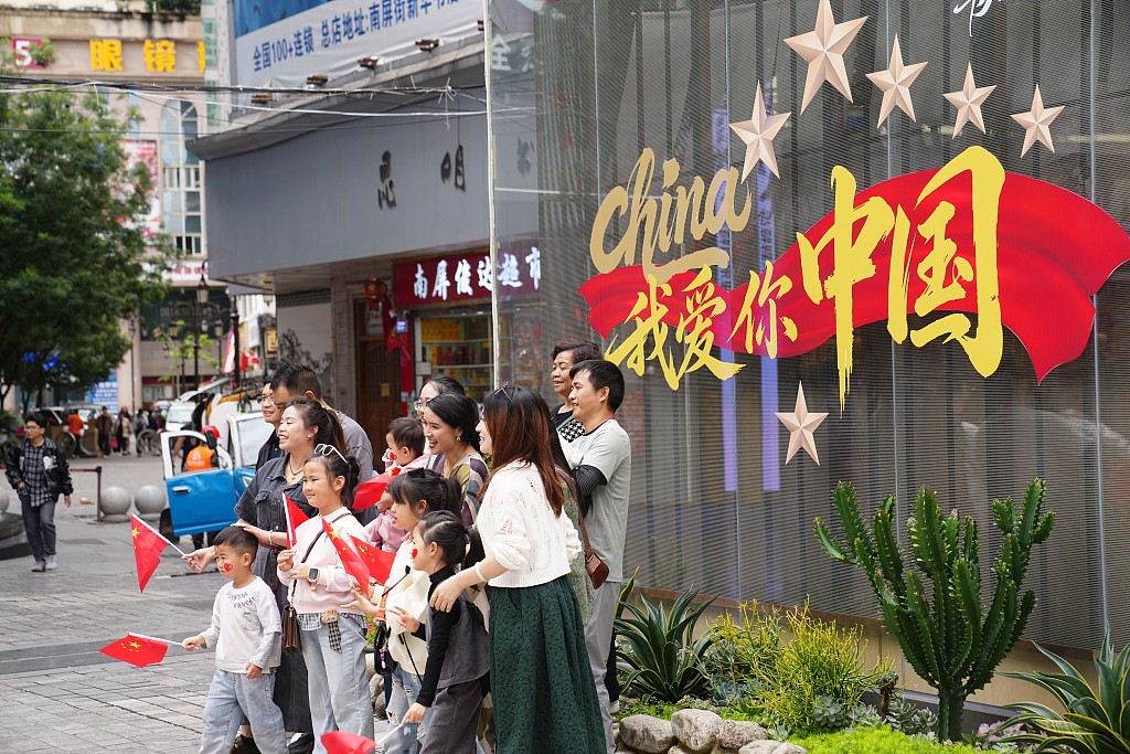 云南昆明：游客手持国旗拍照留念