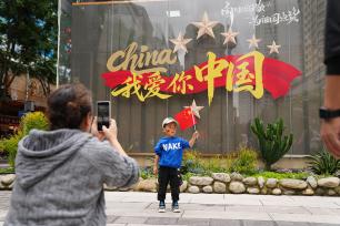 云南昆明：游客手持国旗拍照留念