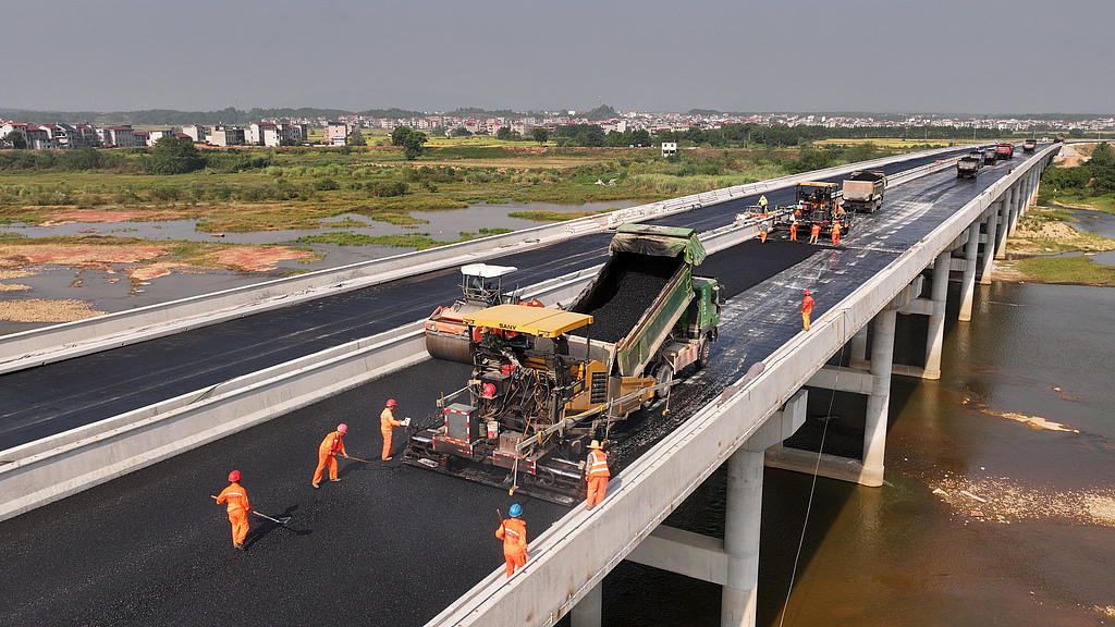 江西吉安：工人为绕城公路摊铺柏油路面