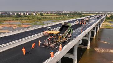 江西吉安：工人为绕城公路摊铺柏油路面