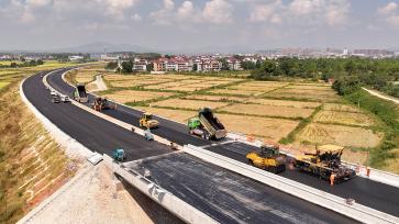 江西吉安：工人为绕城公路摊铺柏油路面