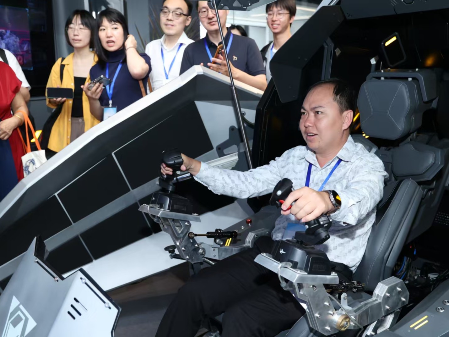 《柬华日报》执行经理欧伟雄在虚拟驾驶室操纵游戏角色“感觉很震撼”