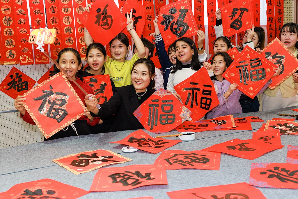新疆乌鲁木齐：小学生写春联送福字