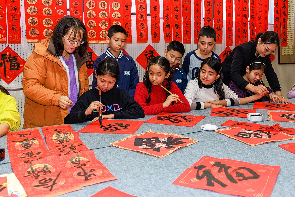 新疆乌鲁木齐：小学生写春联送福字