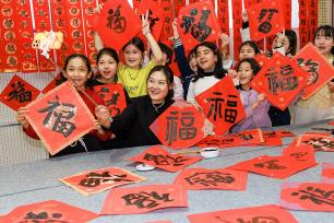 新疆乌鲁木齐：小学生写春联送福字