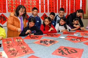 新疆乌鲁木齐：小学生写春联送福字
