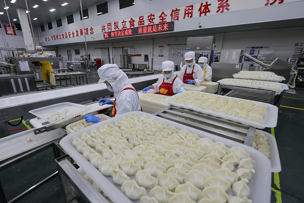山西运城：工人在流水线上加工速冻饺子