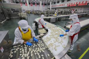 山西运城：工人在流水线上加工速冻饺子